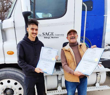 Sage graduates proudly holding up their certificates of completion.