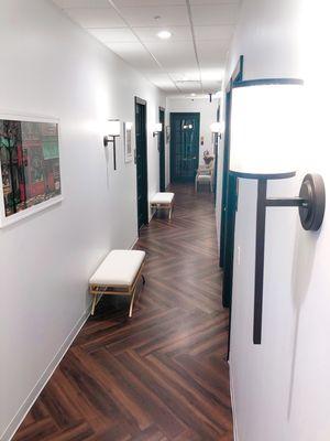 Sconce lighting and bench seating down all our hallways to keep everyone distanced while waiting for their appointment!