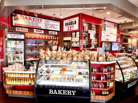 Left side of front counter with bagel case, bakery cases, mustard, pickles, bagel chips, sodas and more