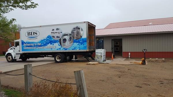 Delivering and installing new machines at a coin laundry location.