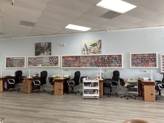 Manicure stations with nail polish colors displayed on the wall.