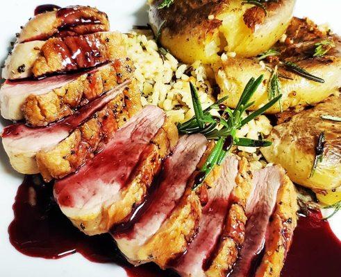 Pan Roasted Duck Breast drizzled over Wild Rice and served with Smashed Yukon Potatoes