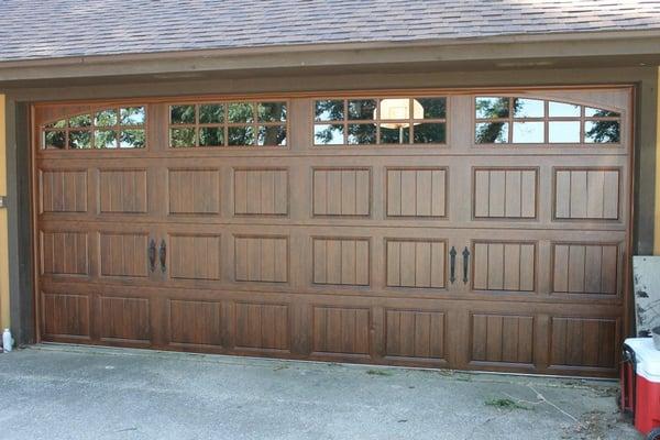 The new garage door in this photo is a garage door we installed that has a "wood Look finish" The garage door is actually a steel door.