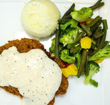 Chicken fried steak with mashed potatoes & gravy and seasonal vegetables