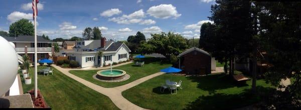 View from the upper pool deck. American flag, Hammock, waterfall, chairs, umbrellas, grill, bicycles