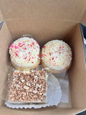 Vanilla cupcakes with buttercream frosting, and an almond cake square.