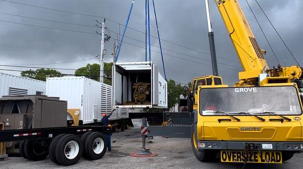 Crane assistance loading a commercial generator for client delivery.