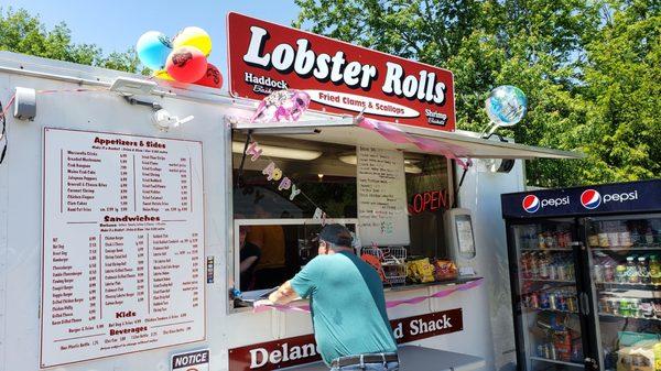 Prices from the menu board updated on the whiteboard beside the window. Lobster rolls have gone up in price