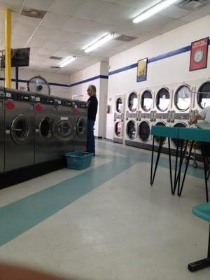 Row of washers for oilfield clothes. Dryers line the walls.