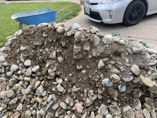 Dirt and gravel in load of medium cobble river rock