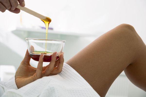 Body Waxing-Beautician prepares wax for a beauty treatment