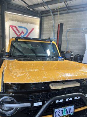 In process; 2022 Ford Bronco with full front paint protection film using STeK film with a 10 year warranty