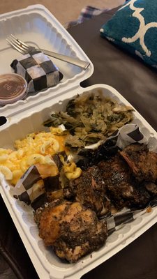 Jerk chicken dinner with sides of Mac-n-cheese and collard green/cabbage mix.