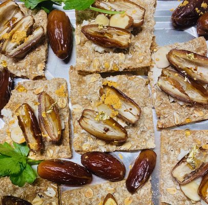 European crackers with dates, goat cheese, almond slices, honey drizzle and edible gold - Feb 2024 Bachelorette Party for 16