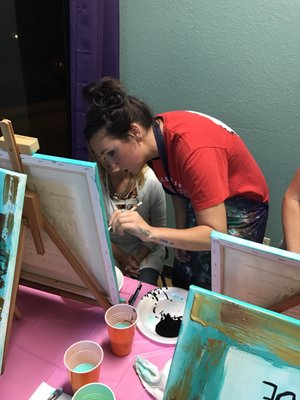 Kaitlyn, the owner and artist, helping out one of the painters.