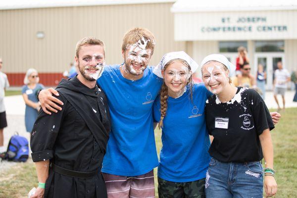 Religious brother poses with missionaries after being pied in the face