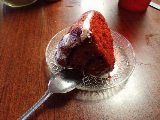 Slice of red velvet cake.  Notice they serve with a spoon.