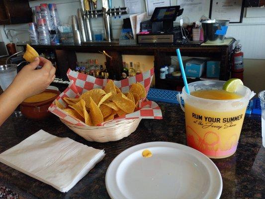 Bucket mango margarita and chips with queso