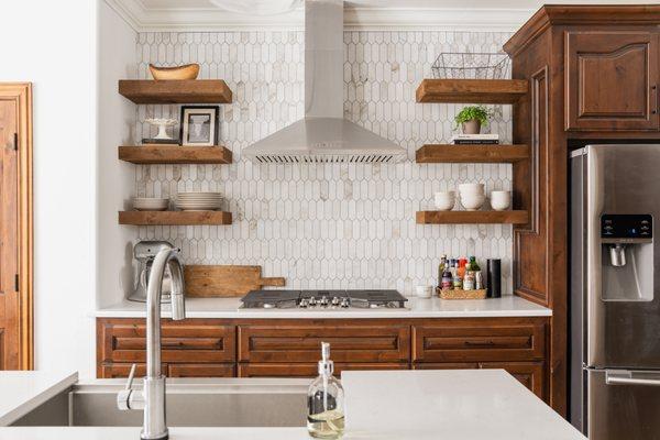 Beautiful contemporary backsplash and hood vent with floating shelves and new island.