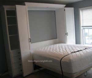 Queen size white Murphy bed opened.  Unit has fold down desk and file drawers right side, book case with 4 drawer base left side.