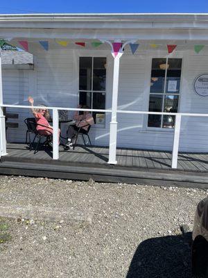 Comfy side porch, shy friends waving happy birthday