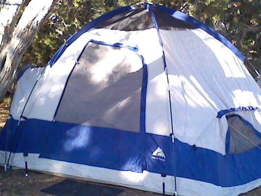 Our tent set up with solar lights and a rug at the enterance