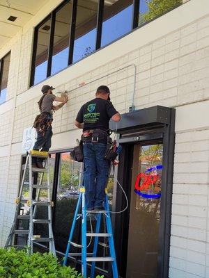 Two of our team members installing Live Guard Video Monitoring Camera  for a cannabis dispensary.