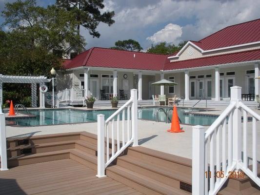 The community salt water swimming pool with the clubhouse in the background