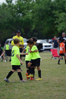 The photograph encapsulates a fusion of emotions players celebrating a goal at a Tournament Final.