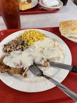 Chicken fried steak with mashed potatoes and white gravy, corn and purple hill peas and corn bread