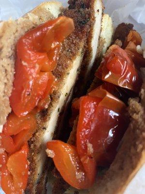 Chicken cutlet, roasted red peppers, provolone, balsamic dressing, & olive oil dressing on a roll.