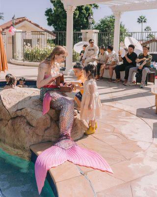 Mermaid Artemisa and a young guest admire mermaid treasures!