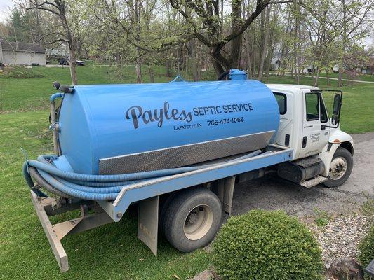 A septic service pumper truck. White cab with blue tank.