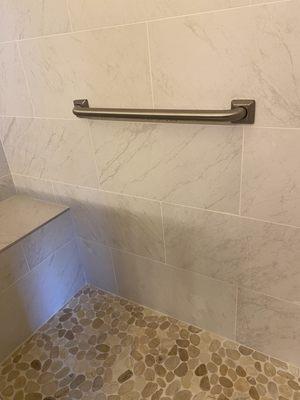 Stone pebble shower floor is natural, non-slip and adds visual interest to the shower. The shower seat is comfortable and a safety feature.