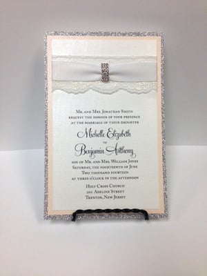 3 Layer Invitation. White Shimmer on Blush and Silver Sparkle Backers, White ribbed Ribbon on White Lace, Jeweled Buckle.