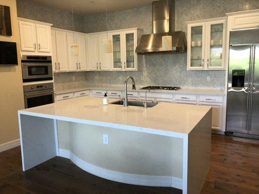 Quartz countertops with waterfall and marble backsplash