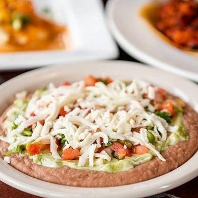 Creamy bean layered dip is refried beans, Pico De Gallo topped Queso Fresco.