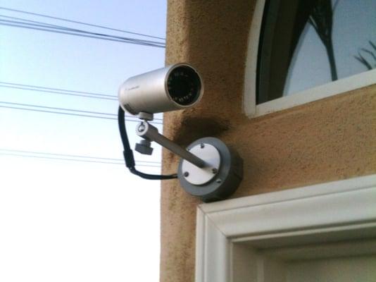 A wireless outdoor camera by Alarm.com mounted by the front door