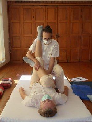 A leg stretching technique performed at Sunshine Massage School in Chiang Mai, Thailand