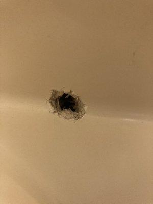 Hole that's been carved into tub.  Maybe even bullet hole.