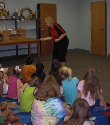 Valerie Oliver from Whirled on a String shows kids some yoyo tricks at Summer Reading Club