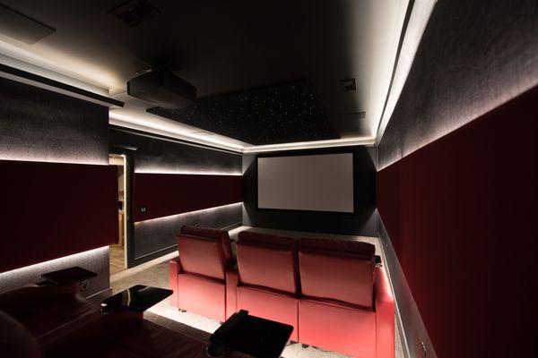 Custom home theater design with theater seating, rope lighting, acoustic panels and Dolby Atmos surround sound