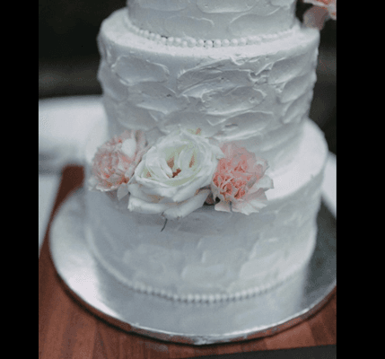 Textured buttercream. Didn't melt at all! We added our own flowers after delivery to save money.