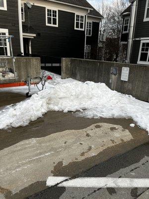 Snow plowed to block walkway.