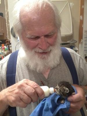 Volunteer David bottle feeding a newborn