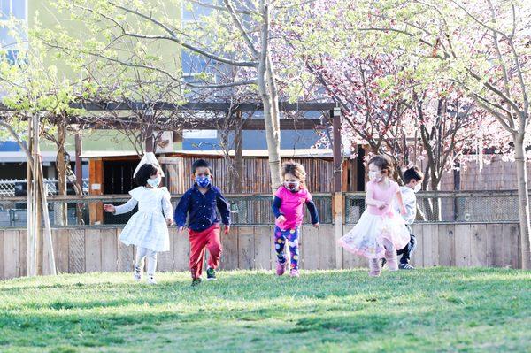 Wearing masks outside doesn't stop the fun on the grassy hill