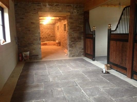 Recycled Rubber Flagstones installed inside a barn in front of horse stalls.