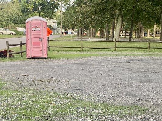 Gravel parking lot dedicated to the playground and a portable toilet