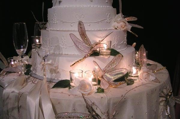 Wedding cake decorated with our dragonflies, satin ribbons, and tea lights.