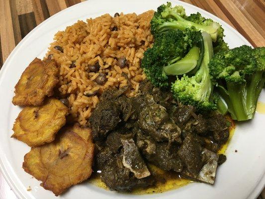 Curry Goat with Pigeon Peas Seasoned Rice, Steamed Broccoli and Tostones